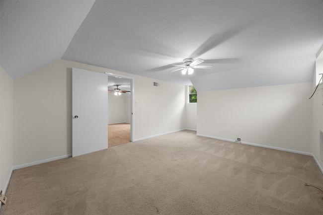 Additional living space with ceiling fan, light colored carpet, lofted ceiling, baseboards, and a textured ceiling | Image 26