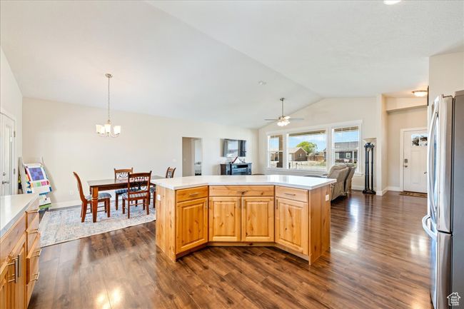 Kitchen featuring vaulted ceiling, open floor plan, light countertops, and freestanding refrigerator | Image 15