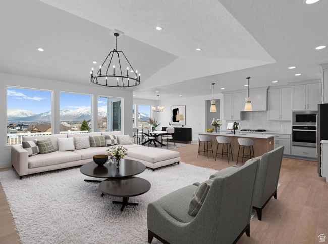 Living room with light wood-type flooring, lofted ceiling, recessed lighting, a mountain view, and an inviting chandelier | Image 6