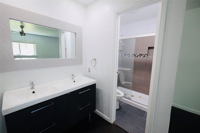 Bathroom featuring double vanity and a shower stall | Image 30