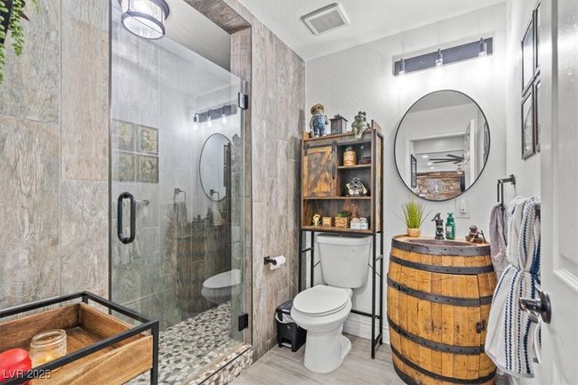 Bathroom with a stall shower, toilet, vanity, wood finished floors, and visible vents | Image 13