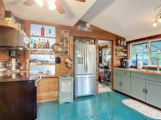 Kitchen has built in storage, solid wood cabinetry, some with pullouts, stainless steel appliances, and has additional storage available in the laundry/mud room | Image 18