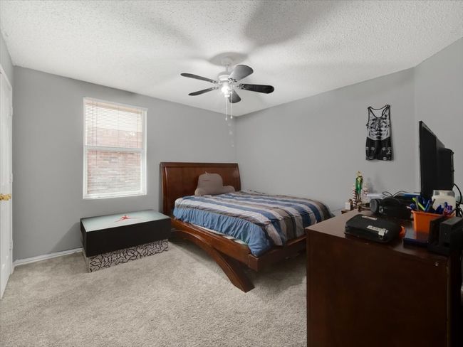 Bedroom with ceiling fan, light colored carpet, and a textured ceiling | Image 22