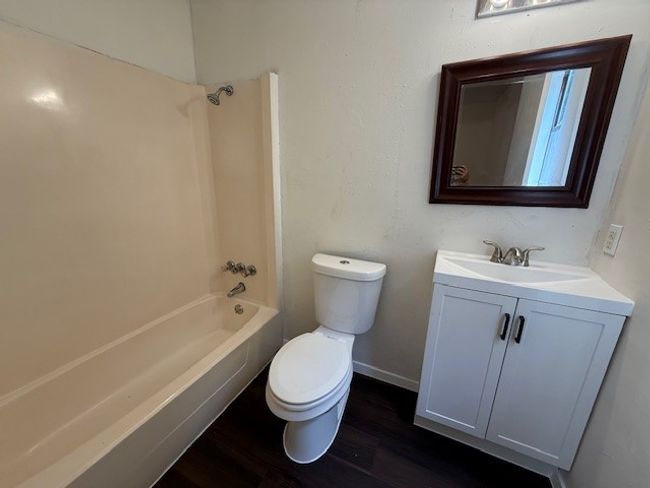 Bathroom featuring toilet, vanity, wood finished floors, and bathing tub / shower combination | Image 8
