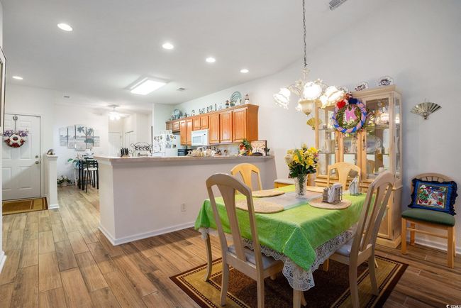 Dining space with light wood-style floors, recessed lighting, and a chandelier | Image 10