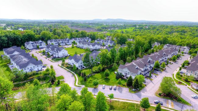 Aerial view of residential area featuring a heavily wooded area | Image 39