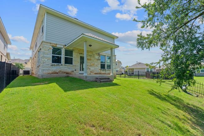 Rear view of house featuring stone siding and a fenced backyard | Image 35