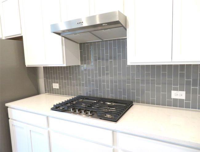 the kitchen has a gas cook top | Image 17