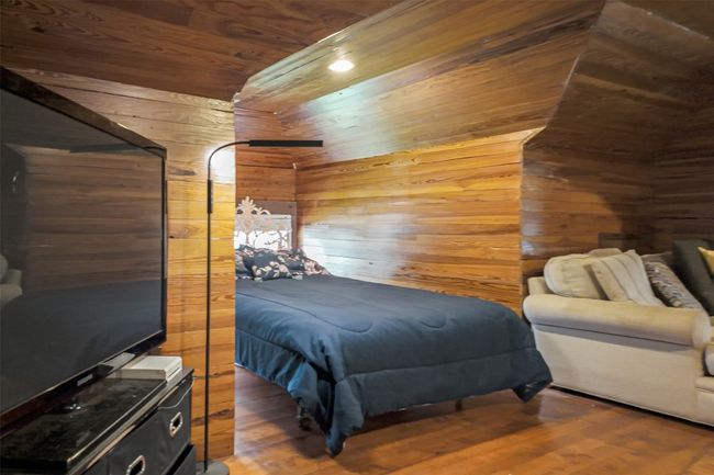 Bedroom featuring wooden walls, wooden ceiling, and wood finished floors | Image 32