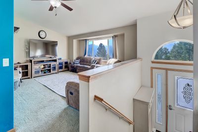 Carpeted living room with lofted ceiling and ceiling fan | Image 3