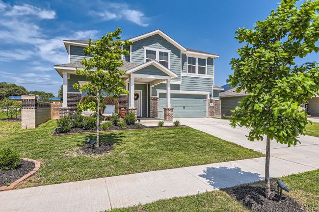 View of front of property with brick siding, concrete driveway, an attached garage, roof with shingles, and a front lawn | Image 5