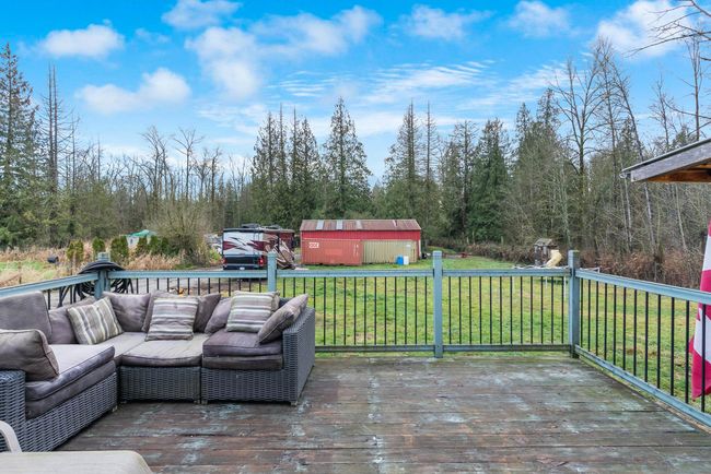 Deck with an outdoor living space, an outbuilding, a lawn, and a shed | Image 27
