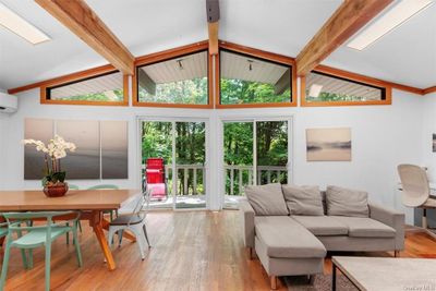 Living room featuring high vaulted ceiling, beamed ceiling, and hardwood / wood-style flooring | Image 1