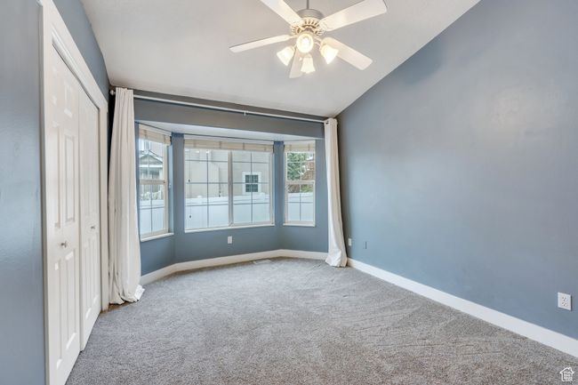 Unfurnished bedroom featuring vaulted ceiling, a ceiling fan, a closet, carpet, and baseboards | Image 17