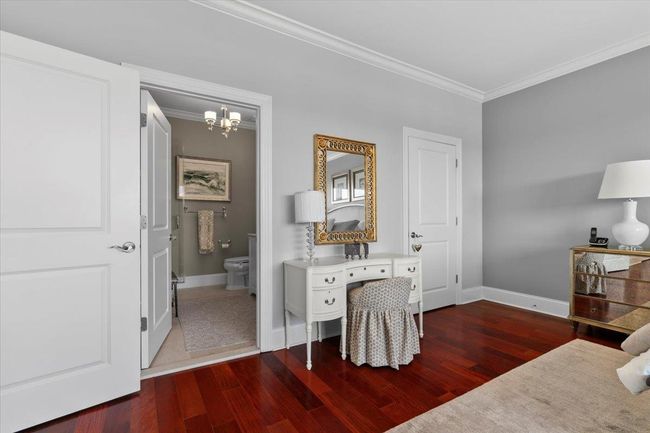 Bedroom with an inviting chandelier, ornamental molding, baseboards, and wood finished floors | Image 13