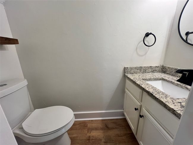 Half bath featuring wood finished floors, toilet, vanity, and baseboards | Image 7