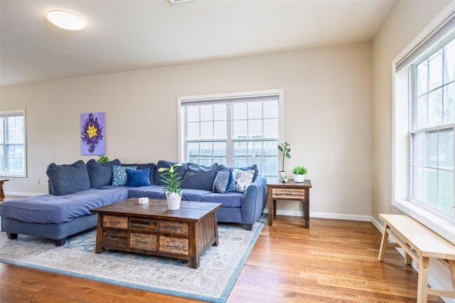 Living area featuring baseboards, a healthy amount of sunlight, and light wood-type flooring | Image 4