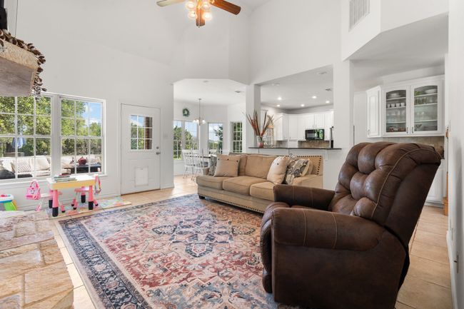 Living area featuring a high ceiling, ceiling fan, and light tile patterned floors | Image 10