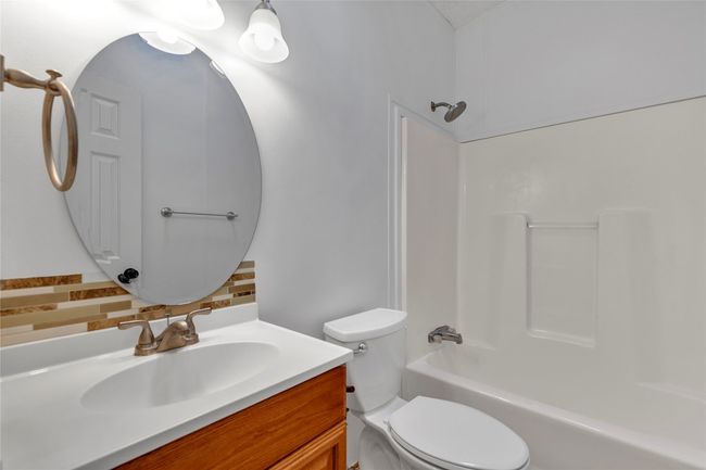 Bathroom with decorative backsplash, vanity, and shower / bath combination | Image 19