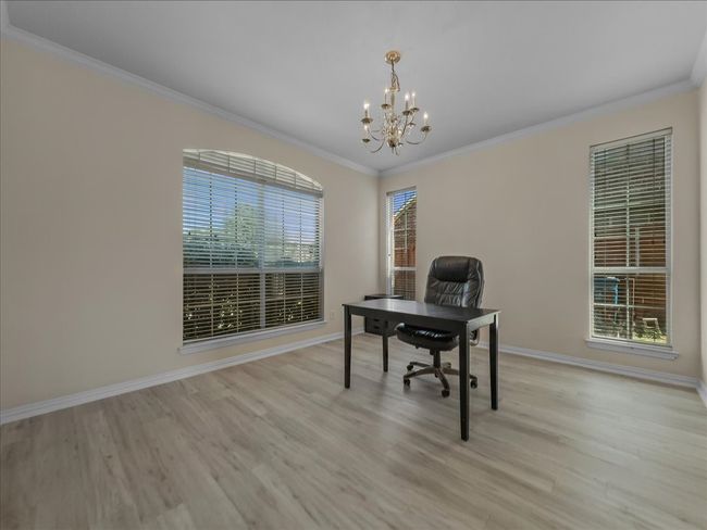 Home office with ornamental molding, a chandelier, and light wood-style flooring | Image 11