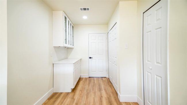 Hallway with visible vents, baseboards, light wood finished floors, and recessed lighting | Image 12