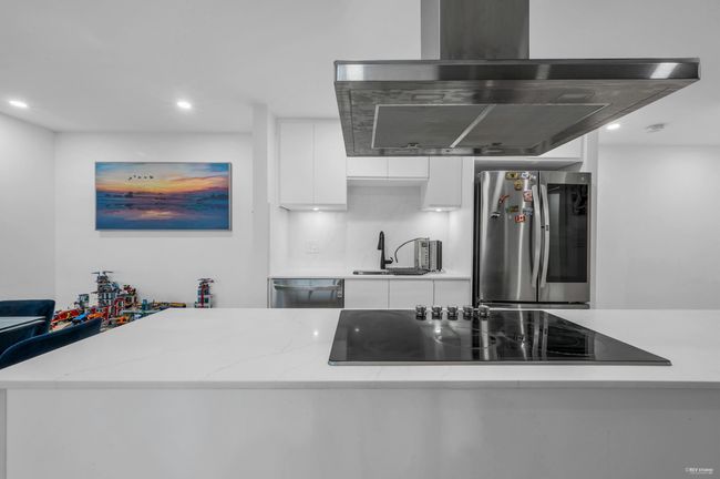 Kitchen with white cabinetry, island range hood, stainless steel appliances, recessed lighting, and modern cabinets | Image 17