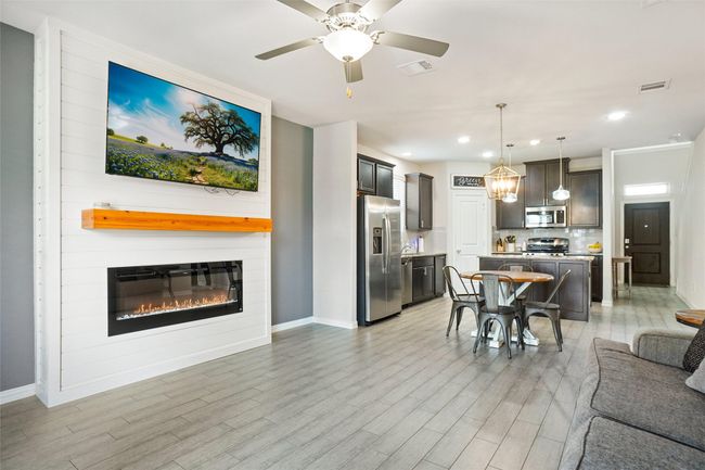 Living room with light wood-style flooring, baseboards, a fireplace, recessed lighting, and a ceiling fan | Image 5