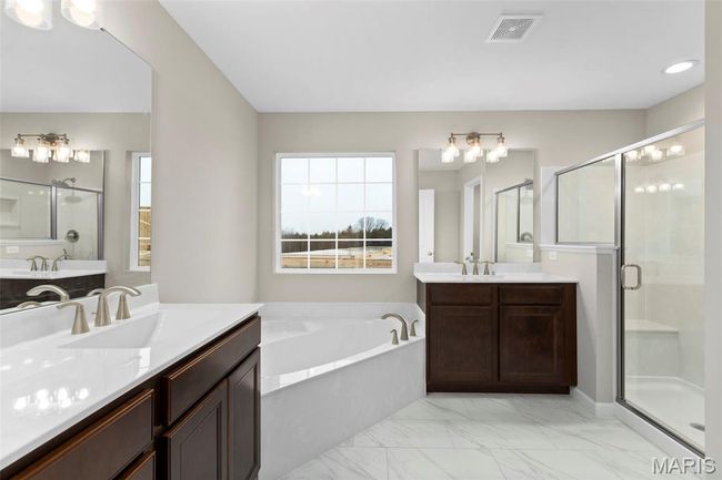 Full bathroom featuring a stall shower, a garden tub, healthy amount of natural light, and two vanities | Image 20
