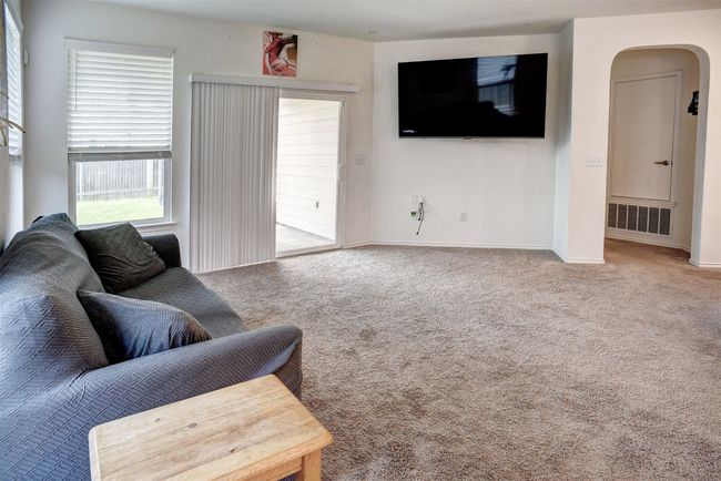 Carpeted living area featuring arched walkways and baseboards | Image 17