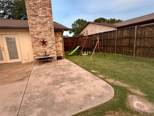 Fenced backyard featuring a playground and a patio | Image 38