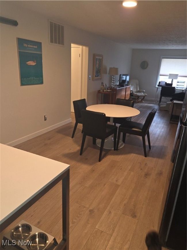 Dining space with visible vents, baseboards, and light wood-style flooring | Image 15
