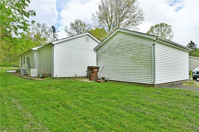 View of property exterior featuring a lawn and cooling unit | Image 45