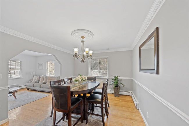 Dining room with an inviting chandelier, ornamental molding, and light wood-style floors | Image 27