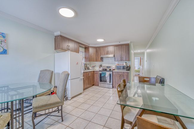 Kitchen featuring appliances with stainless steel finishes, ornamental molding, light tile patterned floors, backsplash, and light countertops | Image 19
