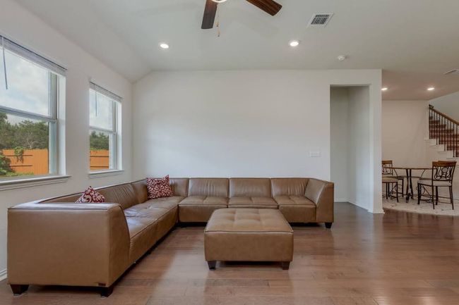 Living room featuring wood finished floors, ceiling fan, stairs, lofted ceiling, and recessed lighting | Image 14