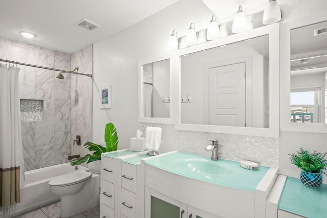 Spacious guest bathroom with custom cabinets, lots of lighting, and a tiled bathtub/shower combo, plus a linen closet. | Image 25