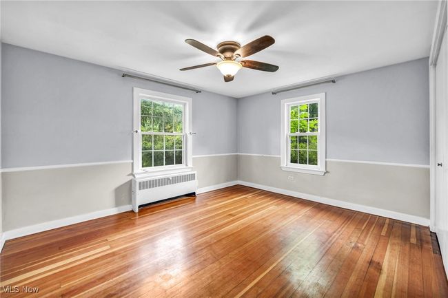 Unfurnished bedroom with a closet, hardwood flooring, and ceiling fan | Image 25
