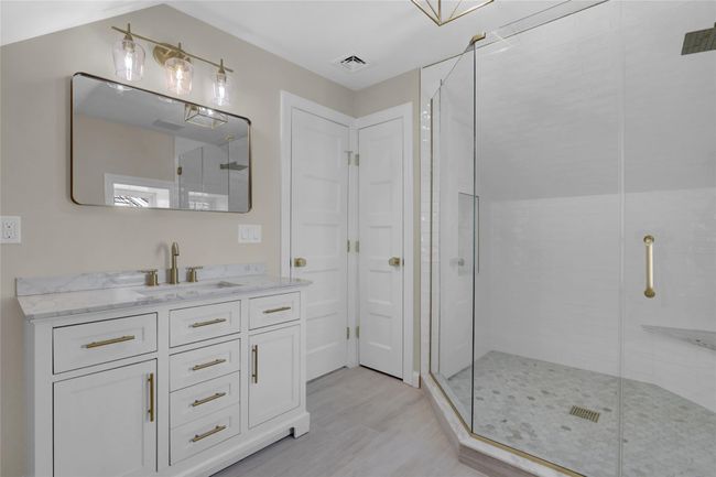 Bathroom with a stall shower, visible vents, wood finished floors, and vanity | Image 23