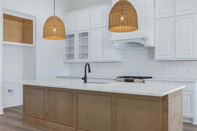 Kitchen with white cabinets and an island with sink | Image 11