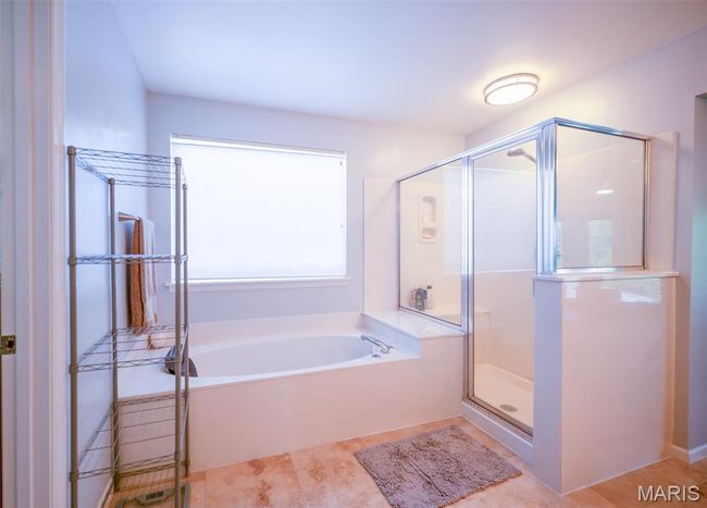 Full bathroom featuring a bath, a shower stall, and tile patterned flooring | Image 29