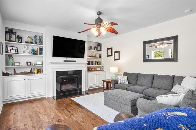 Gas fireplace framed by floor to ceiling built in cabinets & bookshelves | Image 13