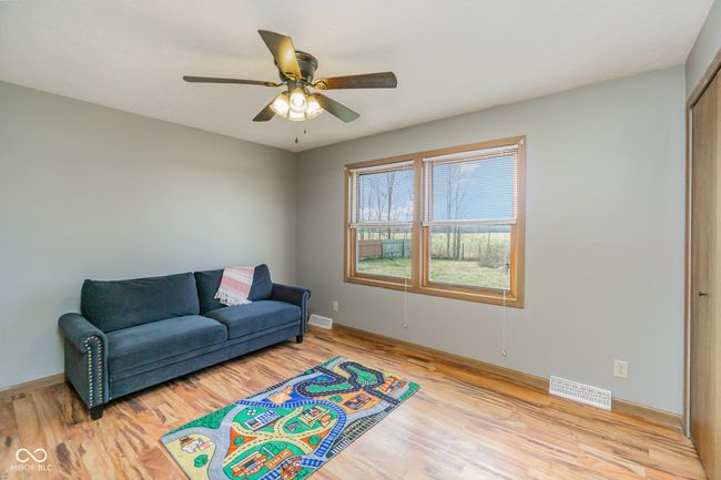 sitting room with light wood finished floors, visible vents, and a ceiling fan | Image 12