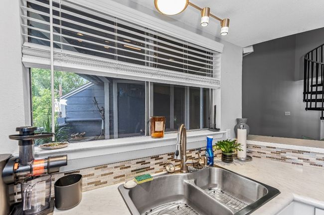 Kitchen view of a sink and tasteful backsplash | Image 10
