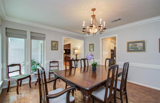Custom pleated fabric shades, crown and chair railing, and the lovely chandalier combine to make this a beautiful entertaining space. | Image 6