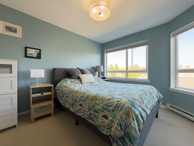 Bedroom with a baseboard heating unit, carpet flooring, and baseboards | Image 24