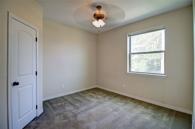 Spare room with a ceiling fan, carpet, and baseboards | Image 11