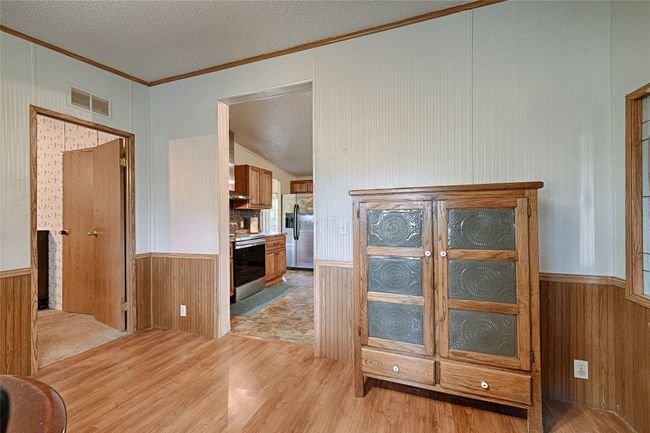 Corridor featuring wood walls, a wainscoted wall, and light wood-style flooring | Image 17