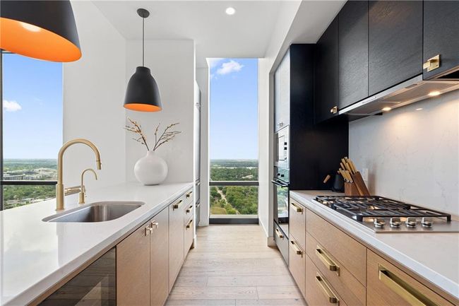 Kitchen featuring a sink, stainless steel appliances, plenty of natural light, and light wood-style floors | Image 9