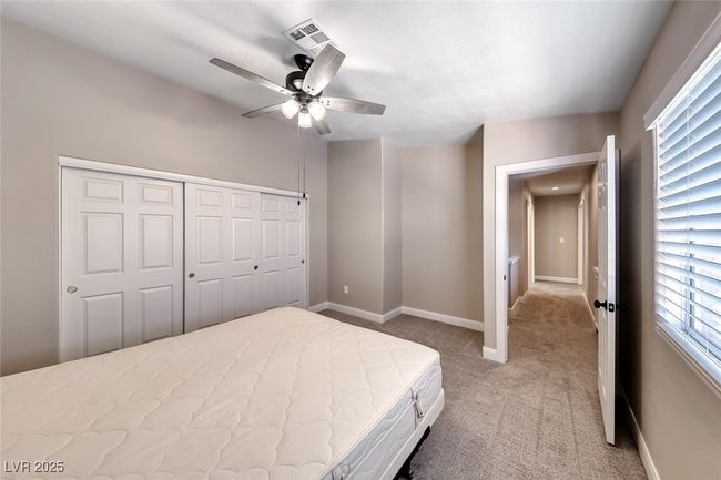 Bedroom with light colored carpet, a closet, and ceiling fan | Image 25