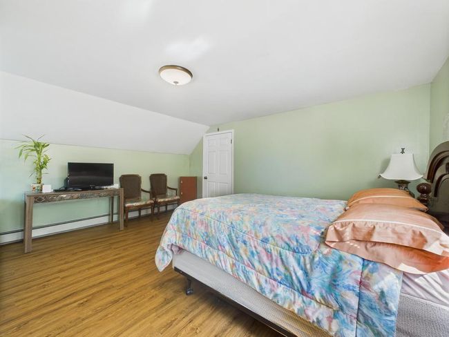 Bedroom with light wood-style floors and vaulted ceiling | Image 16